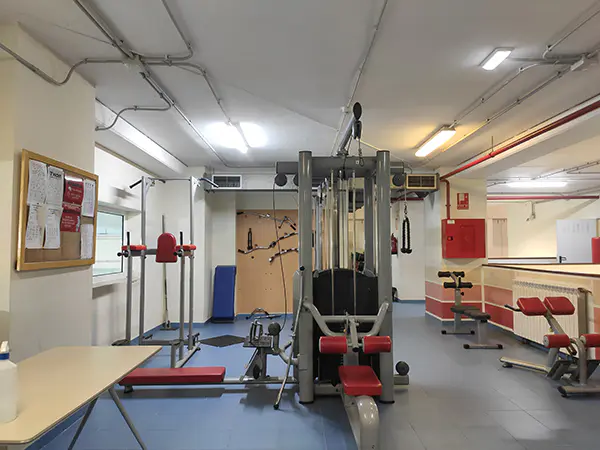 Gimnasio interior, con máquinas y bancos de musculación