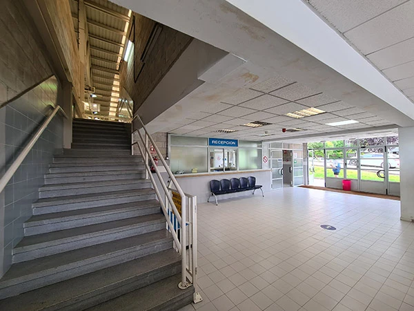 Vestíbulo y recepción del polideportivo. Escaleras de acceso a planta superior