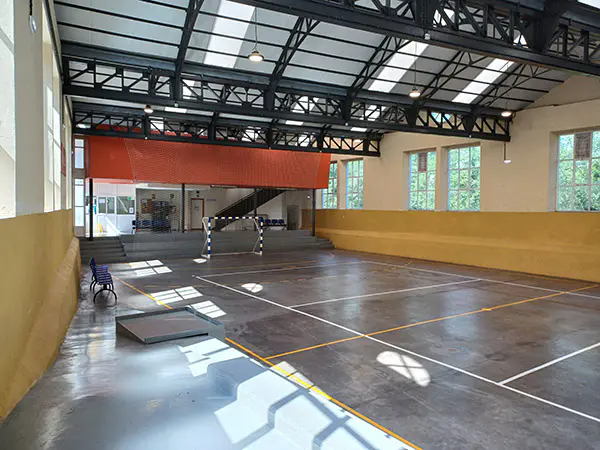 Rampa para personas con movilidad reducida. Parte de la pista y recepción. Al fondo, acceso a planta de vestuarios 
