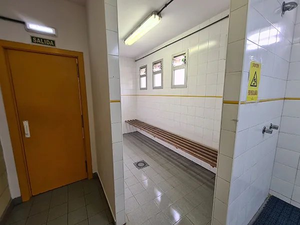 Vista de las duchas y puerta de salida de un vestuario