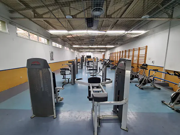Vista del gimnasio, con bicicletas estáticas y bancos de musculación