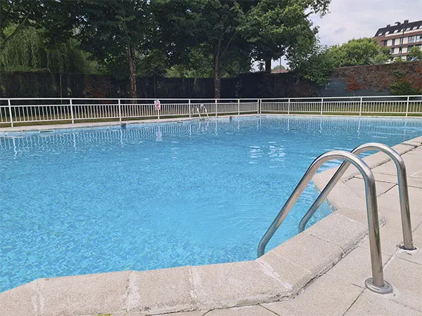 vista del vaso de la piscina con escalera de acceso en primer plano