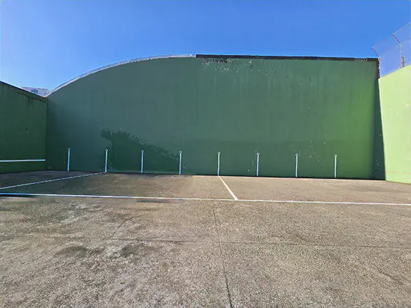 Panorámica de la pista exterior de frontón del centro deportivo, con vista del frontis