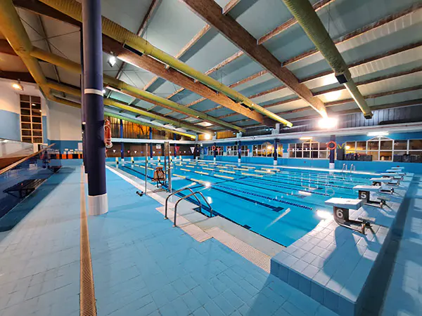 Piscina del centro deportivo, con vista en detalle de las plataformas de salida y las barandillas de acceso
