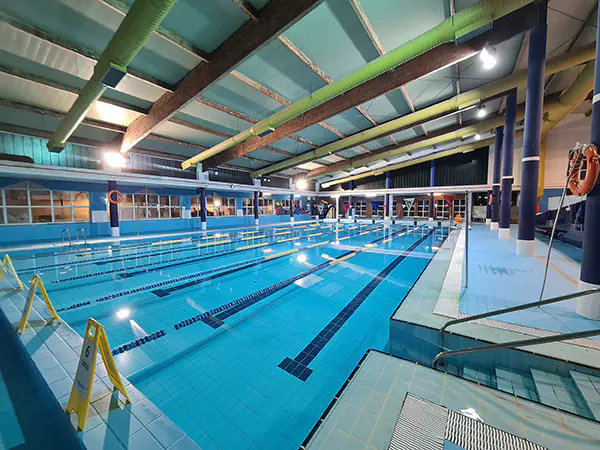 Panorámica de la piscina, con vista en detalle de las escalerillas y las barandillas de acceso