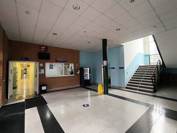 Vestíbulo del polideportivo. Mostrador de información, acceso a vestuarios, aseos y escaleras de acceso a planta superior