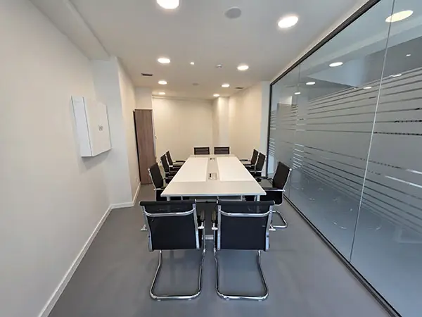 Sala de reuniones del Palacio de los Deportes de Oviedo con mesa de trabajo y espacio para encuentros profesionales