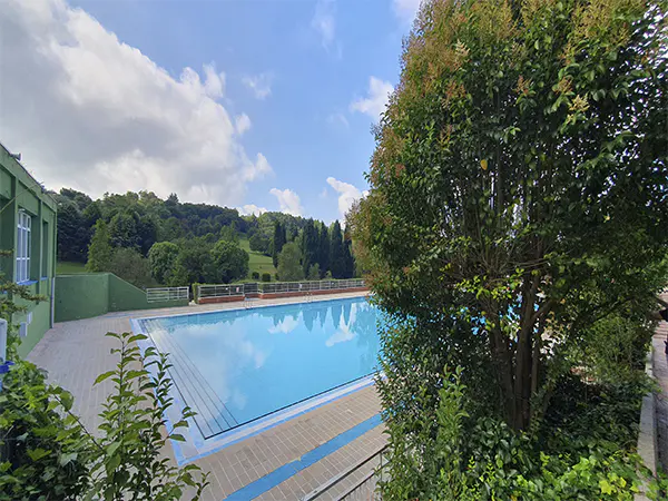 Vista parcial de la piscina principal, desde un pequeño promontorio, rodeada de árboles