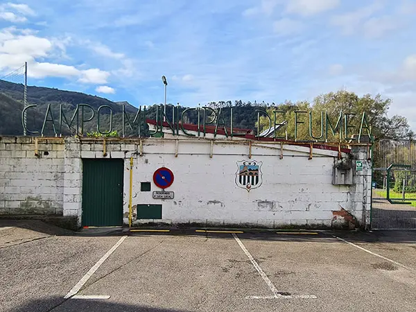 Fachada y puerta de acceso a la instalación con el escudo del equipo Nalón Club de Fútbol.