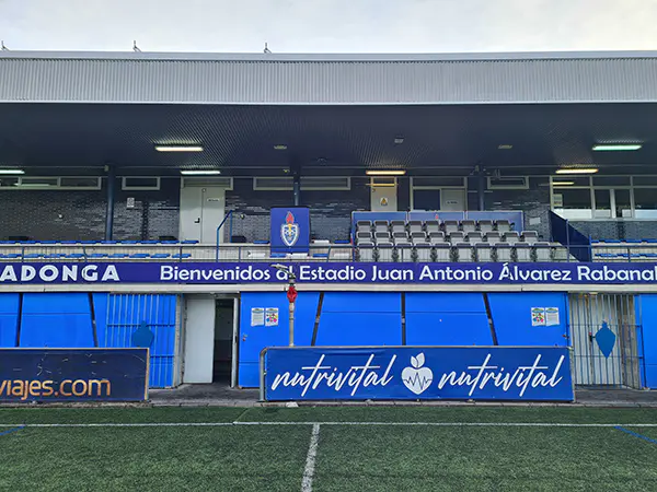 Zona de palcos de la grada cubierta. Sobre fondo azul y, en letras blancas, escrito un mensaje de bienvenida al estadio 