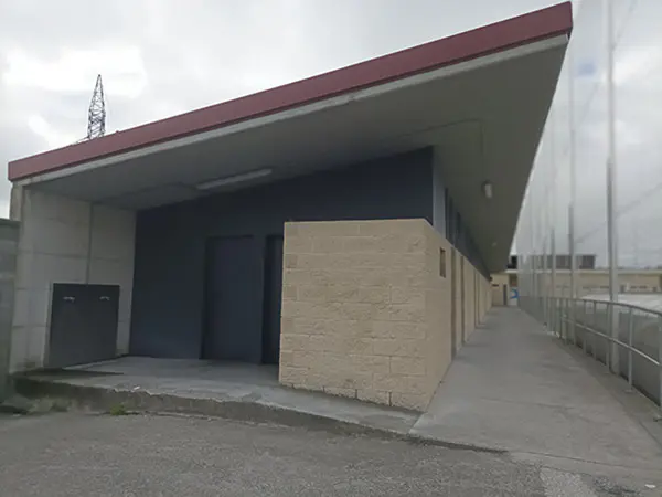 Zona lateral campo de fútbol. Vista edificio junto a un pasillo largo con acceso a vestuarios y demás instalaciones
