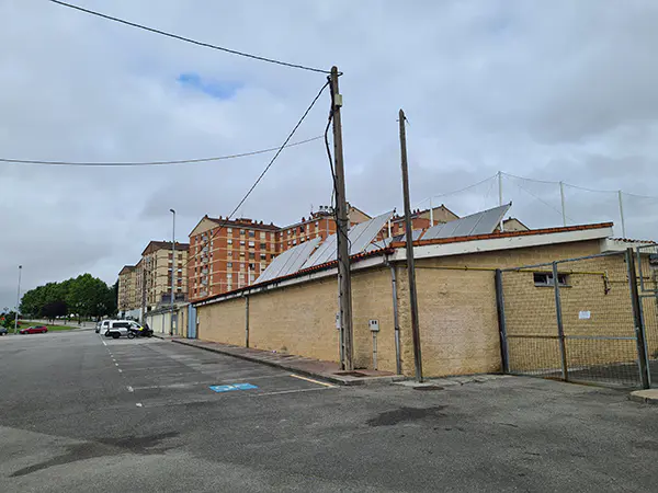 Exterior del campo de fútbol. Vista de las plazas del parking en batería y una reservada a minusválidos 