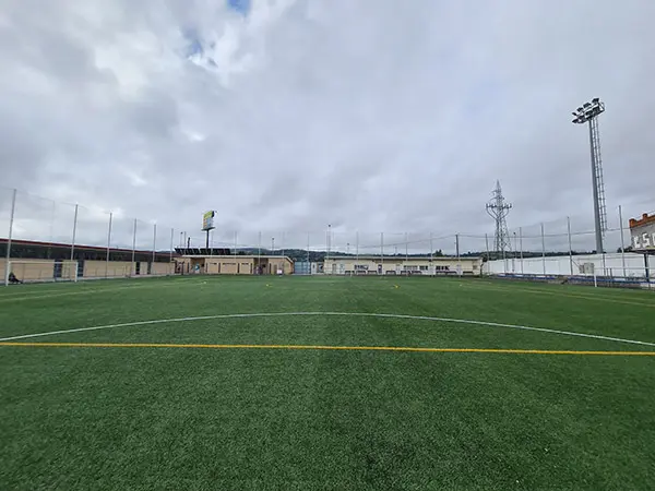 Perspectiva campo de juego desde la portería. Destaca la línea amarilla del área grande y su semicírculo pintado en blanco