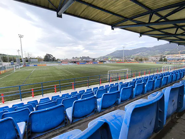 Vista del campo de fútbol desde las gradas cubiertas, con detalle de las butacas