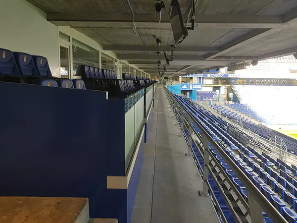 Vista de la zona vip de los palcos y parte de la tribuna con asientos en color azul en hilera