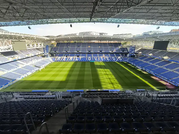 Campo de juego y tribunas desde interior grada. De frente en el anillo azul destaca en letras blancas: Real Oviedo