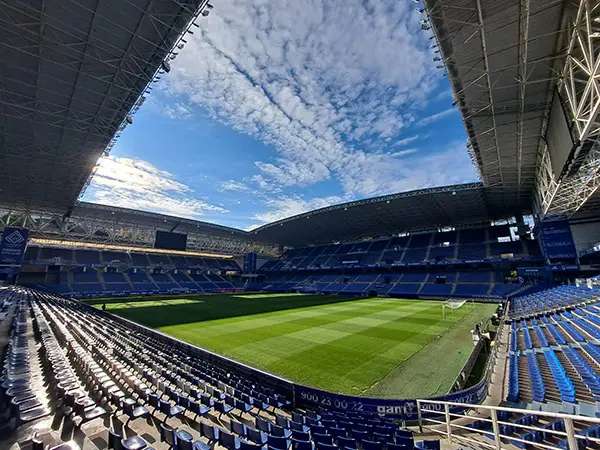 Detalle en perspectiva del Estadio bajo un cielo azul con motas de nubes blancas