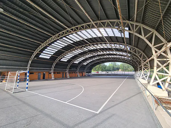 Panorámica de la pista polideportiva, con su cubierta metálica y unas porterías de fútbol 