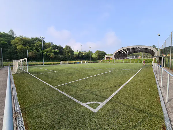 Panorámica de uno de los campos de fútbol 8 desde uno de los córneres, con las porterías y la pista polideportiva al fondo