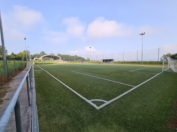 Panorámica de uno de los campos de fútbol 8 desde uno de los córneres, con las porterías y la pista polideportiva al fondo