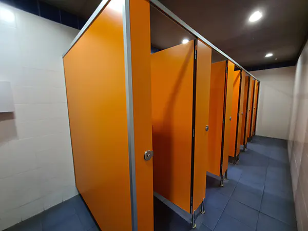 Vista interior de los aseos, con retretes con puertas y mamparas