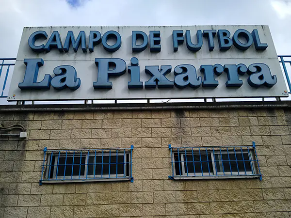 Fachada exterior el edificio del campo de La Pixarra, con letrero en relieve con el nombre de la instalación
