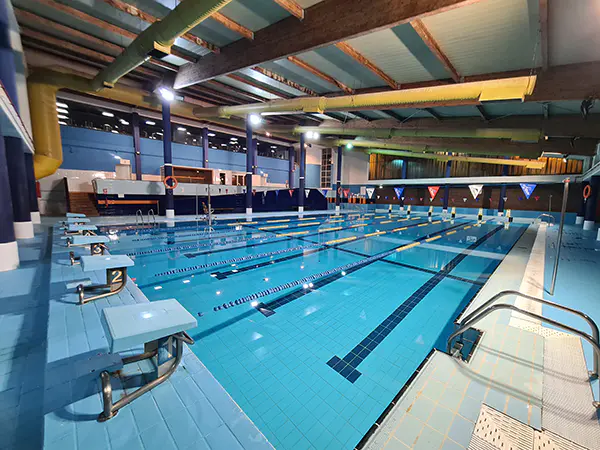 Panorámica de la piscina, con vista en detalle de las plataformas de salida y las barandillas de acceso