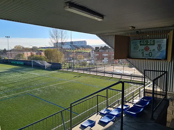 Marcador situado en un muro lateral de la cubierta con gradas azules