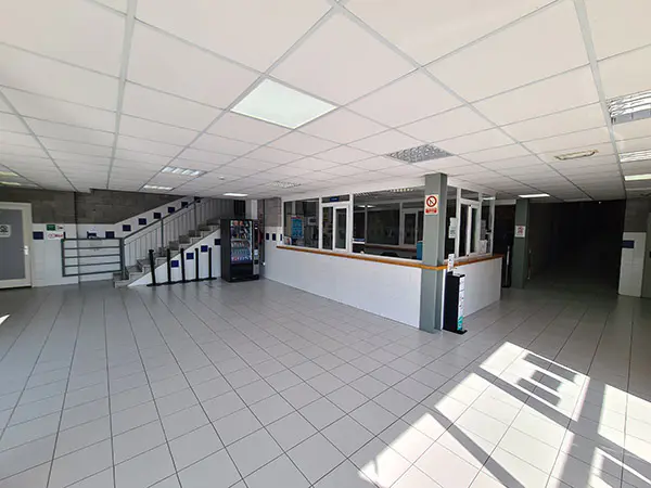 Hall de la entrada principal y recepción del polideportivo, escalera de acceso a planta superior