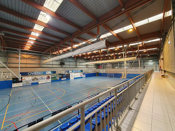 Pasillo de zona superior a las gradas, parte de las gradas y pista polideportiva