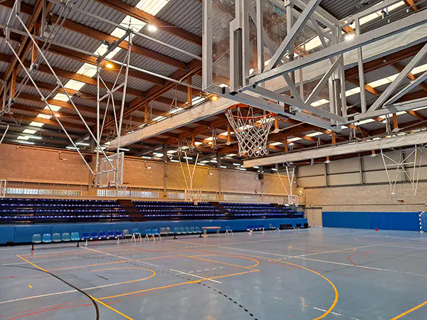 Pista polideportiva,gradas del público. Imagen tomada desde la pista bajo canasta de baloncesto