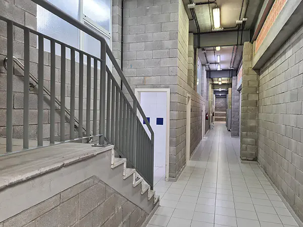 Escalera para subida a planta superior y pasillo de acceso a vestuarios