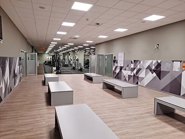 Área de distribución del vestíbulo, con bancos de espera y acceso a la sala de fitness y musculación