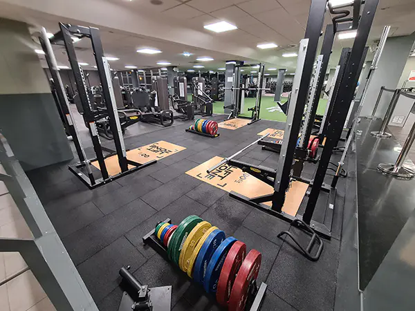 Sala de fitness con máquinas de musculación y pesas