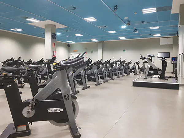 Sala de "bike", con una batería de bicicletas de "spinning" y una tarima con pantalla para el instructor