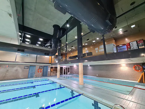 Panorámica de las piscinas climatizadas de entrenamiento y aprendizaje, con vista de la recepción en el piso superior