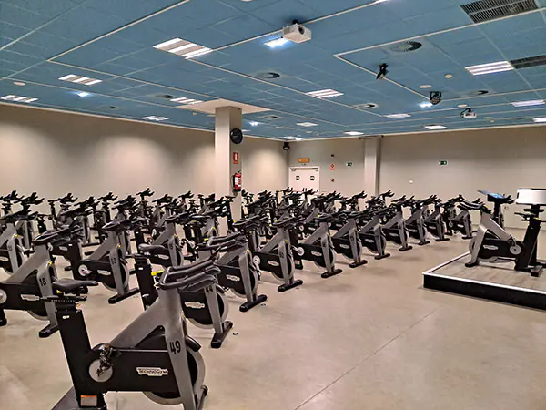 Sala de "bike", con una batería de bicicletas de "spinning" y una tarima con monitor para el instructor