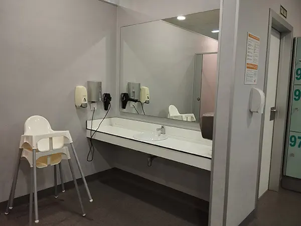 Lavabos de los aseos, con gran espejo, sillas y secador de manos y de pelo 