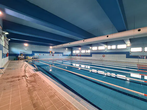 Panorámica lateral de la piscina principal, con vista de las barandillas de acceso