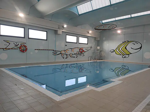 Panorámica de una de las piscinas de aprendizaje, con pinturas de animales, de carácter infantil, en las paredes